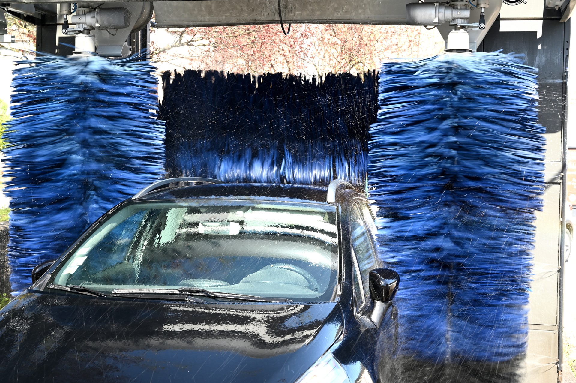 black car being washed at an automatic car wash station